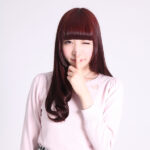 人差し指を伸ばしてナイショのポーズをする女性